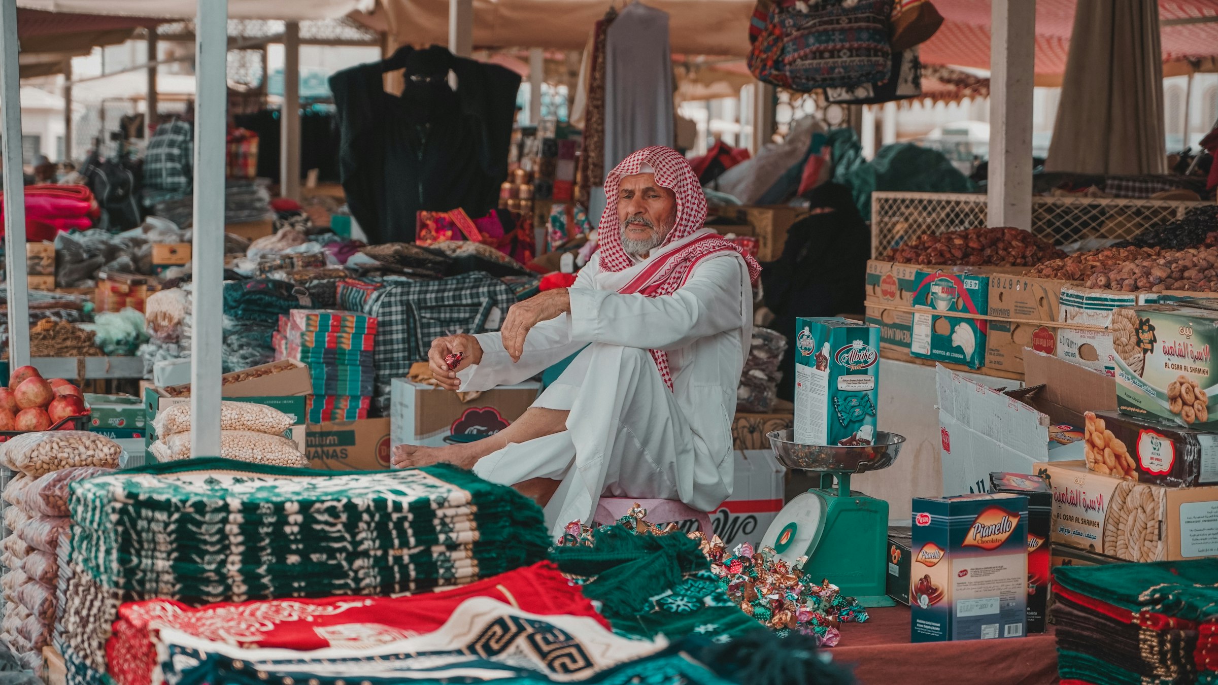 A shopkeeper among his cloth in a market in Madinah